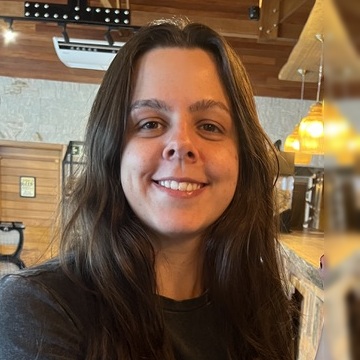 marcella sorrindo, sentada num café